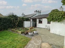 A garden with a pathway and plant pots at Bwthyn in Moelfre