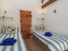 A bedroom with two beds and a wooden door at Dale Barton in Wells