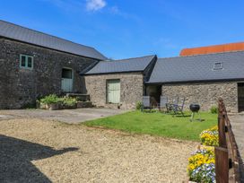 An outdoor area with stone buildings and garden furniture at Dale Barton in Wells