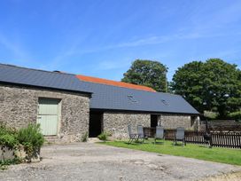 A stone building with a green door and chairs outside at Dale Barton in Wells