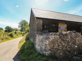 A stone building near a road with a sign at Dale Cottages in Wells