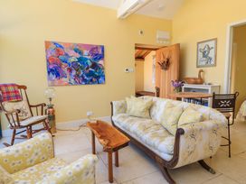 A living room with sofa and artwork at Pheasant Cottage in Priston Village, BATH