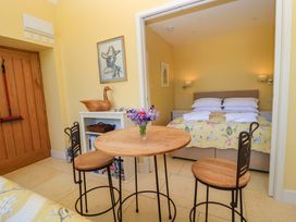 A bedroom with a bed and table at Pheasant Cottage in Priston Village, BATH