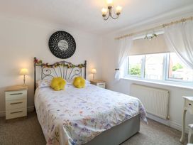 A bedroom with a bed, bedside tables and lamps at Breydon Cottage, Bradwell near Gorleston-On-Sea