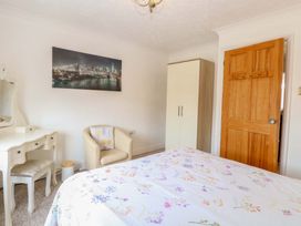 A bedroom with a wardrobe and dressing table at Breydon Cottage in Bradwell near Gorleston-On-Sea