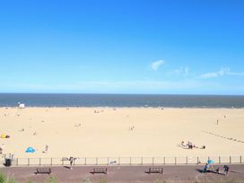 A beach with people and benches at Breydon Cottage Bradwell near Gorleston-On-Sea