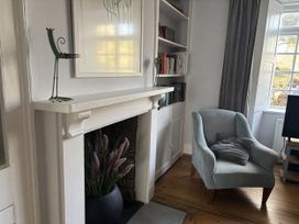 A living room with a fireplace and bookshelf at Brock Cottage in West Bay