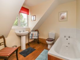 A bathroom with a bathtub sink toilet chair and towels at Wayside Cottage in Pocklington