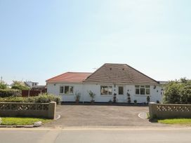 A single story house with two roof sections a driveway and potted plants at Beachway in Talacre near Prestatyn
