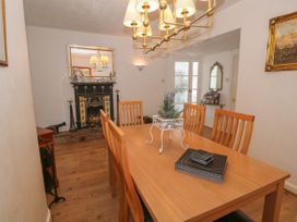 A dining room with wooden table and chairs a decorative fireplace and a chandelier at Beachway Talacre near Prestatyn