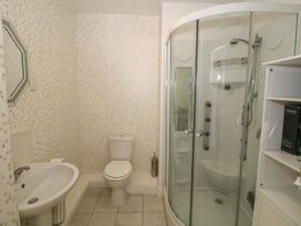 A bathroom with a sink toilet shower cabin and a white shelf unit at Beachway Talacre near Prestatyn