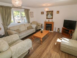 A living room with sofas coffee table fireplace and television at Beachway in Talacre near Prestatyn
