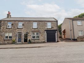 A house with stone facade and garage door at Hasting Dairy in North Sunderland near Seahouses