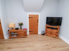 A snug with a television and wooden furniture at Hasting Dairy in North Sunderland near Seahouses