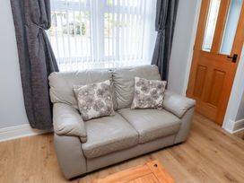 A couch with cushions and a door at Hasting Dairy North Sunderland near Seahouses