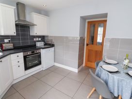 A kitchen with appliances and dining area at Hasting Dairy North Sunderland near Seahouses