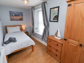 A bedroom with a bed and a wardrobe at Hasting Dairy in North Sunderland near Seahouses