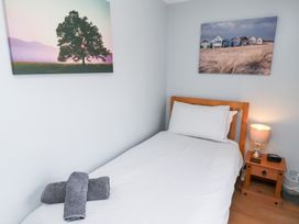 A bedroom with a single bed and wall art at Hasting Dairy North Sunderland near Seahouses