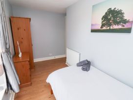 A bedroom with a bed and wardrobe at Hasting Dairy North Sunderland near Seahouses