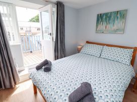 A bedroom with a double bed and door to a balcony at Hasting Dairy in North Sunderland near Seahouses
