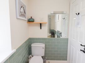 A bathroom with a toilet and a mirror at Hasting Dairy North Sunderland near Seahouses