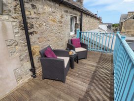 An outdoor area with chairs and a table at Hasting Dairy in North Sunderland near Seahouses