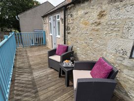 An outdoor seating area with chairs and a small table at Hasting Dairy North Sunderland near Seahouses