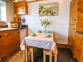 A kitchen with a table set for meals at Woodland Cottage in Garth