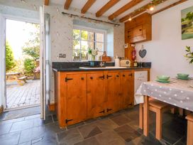 A kitchen with wooden cabinets and a table at Woodland Cottage in Garth
