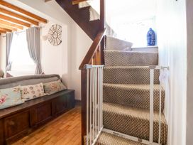 A staircase with a safety gate and a sofa at Woodland Cottage in Garth