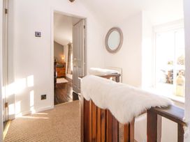 A hallway with a handrail and mirror at Woodland Cottage in Garth