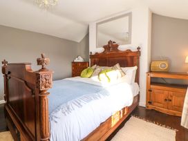 A bedroom with a wooden bed and dresser at Woodland Cottage in Garth