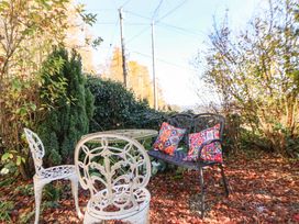 A garden setting with a table and chairs at Woodland Cottage in Garth
