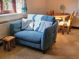 A living room with a sofa and dining table at Chiffchaff in Padstow