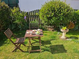 A table with cups and food in a garden at Chiffchaff Padstow