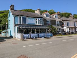 A row of buildings with a cafe called Sea View with outdoor seating on a street at Bay View Apartment in Porthmadog