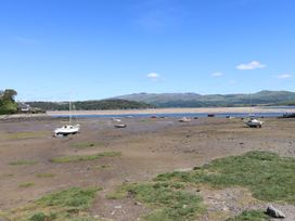 A view of boats in shallow water with grass and hills in the background at Bay View Apartment in Porthmadog