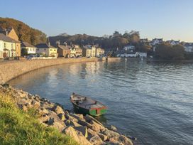 A view of a boat near houses along the water at Bay View Apartment Porthmadog