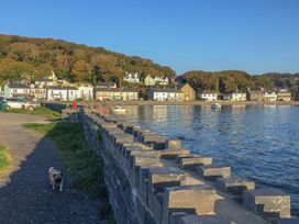 A waterfront view with houses, a dog, and boats at Bay View Apartment in Porthmadog