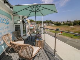 A balcony with chairs and a table overlooking the area at Bay View Apartment in Porthmadog