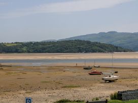 A beach scene with boats on sand at Bay View Apartment in Porthmadog