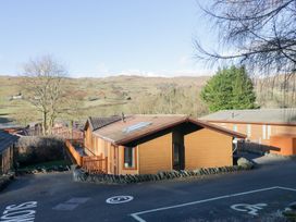 An outdoor view of wooden cabins with trees and hills at Heights View 