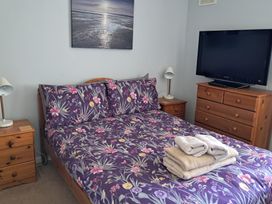A bedroom with a bed and television at The Lookout -The House With A View Weymouth