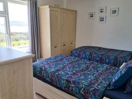 A bedroom with two beds and a wardrobe at The Lookout -The House With A View in Weymouth