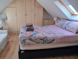 A bedroom with a bed, wardrobe, and lamp at The Lookout -The House With A View, Weymouth
