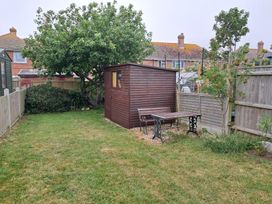 A garden with a shed and table set at The Lookout -The House With A View in Weymouth