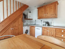 A kitchen with wooden cabinets and appliances at Kernyk in Penzance