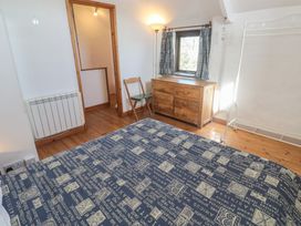 A bedroom with a bed, chest of drawers and a window at Kernyk in Penzance