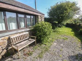 A garden with a wooden bench and greenery at Kernyk in Penzance
