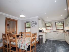 A kitchen with a dining table and chairs at Burnside House in Aviemore